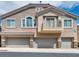 Three-story exterior with gray garage doors and stone accents at 8728 Tom Noon Ave # 103, Las Vegas, NV 89178