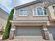 Charming two-story home featuring a two-car garage with stone accents and well-maintained landscaping at 8728 Tom Noon Ave # 103, Las Vegas, NV 89178