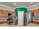 Kitchen featuring stainless steel appliances, wooden cabinets, tile backsplash, and corian countertops at 8728 Tom Noon Ave # 103, Las Vegas, NV 89178