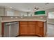 Kitchen featuring stainless steel appliances, wooden cabinets, tile backsplash, and corian countertops at 8728 Tom Noon Ave # 103, Las Vegas, NV 89178