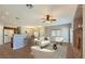 Open-concept living room showcasing a fireplace, ceiling fan, bar seating, and hardwood floors at 8728 Tom Noon Ave # 103, Las Vegas, NV 89178