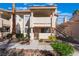 Inviting condo exterior with a gated front patio, mature landscaping and stairway to the upper unit at 912 Falconhead Ln # 101, Las Vegas, NV 89128