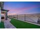 Backyard of a home with artificial grass, a metal fence, and a covered patio with outdoor furniture at 964 Edinburgh Fields Ct, Las Vegas, NV 89138