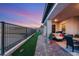 A beautiful backyard has artificial turf and a covered patio with outdoor furniture and a twilight sky at 964 Edinburgh Fields Ct, Las Vegas, NV 89138