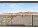 A second story balcony with a metal railing offers views of the desert community at 964 Edinburgh Fields Ct, Las Vegas, NV 89138