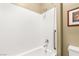 Bright bathroom with a white tiled shower-tub, chrome fixtures and a safety hand rail at 964 Edinburgh Fields Ct, Las Vegas, NV 89138