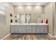 Well-lit bathroom with double vanity, gray cabinetry, and large mirrors above at 964 Edinburgh Fields Ct, Las Vegas, NV 89138