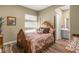 Charming bedroom featuring a four-poster bed, neutral walls, and adjacent bath at 964 Edinburgh Fields Ct, Las Vegas, NV 89138