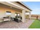 Large, covered patio with grill, seating, desert landscaping and view of the community at 964 Edinburgh Fields Ct, Las Vegas, NV 89138