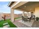 Beautiful covered patio area with dining and lounging furniture and desert landscaping at 964 Edinburgh Fields Ct, Las Vegas, NV 89138
