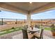 Comfortable covered patio area with table, chairs and desert landscaping in the backyard at 964 Edinburgh Fields Ct, Las Vegas, NV 89138
