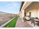 Inviting covered patio has artificial grass, desert plants, and backyard seating with view at 964 Edinburgh Fields Ct, Las Vegas, NV 89138