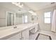 Bright bathroom features a double vanity, large mirror, and tiled flooring at 9717 Villa Lorena Ave, Las Vegas, NV 89147