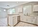 Updated kitchen with white cabinets, stainless steel dishwasher, and eat-in counter at 9717 Villa Lorena Ave, Las Vegas, NV 89147