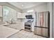 Modern kitchen with stainless steel appliances, white cabinets, and tiled flooring at 9717 Villa Lorena Ave, Las Vegas, NV 89147