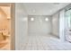 Well-lit space with white tile floors, sliding glass door, and a glimpse of a half bathroom at 9717 Villa Lorena Ave, Las Vegas, NV 89147