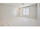Neutral living room with light tile flooring, a bright window, and a view of the front door at 9717 Villa Lorena Ave, Las Vegas, NV 89147