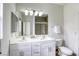 Bathroom with double vanity, large mirror and a glass-enclosed tiled shower at 9966 Mystic Moss St, Las Vegas, NV 89183
