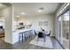 Bright dining area adjacent to kitchen featuring a modern table, barstool seating, and sliding glass doors at 9966 Mystic Moss St, Las Vegas, NV 89183