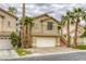 Inviting two-story home with a terra cotta roof, two-car garage and manicured landscaping with tall palm trees at 9966 Mystic Moss St, Las Vegas, NV 89183