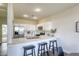 Bright and modern kitchen featuring white cabinets, quartz countertops, stainless steel appliances, and barstool seating at 9966 Mystic Moss St, Las Vegas, NV 89183