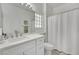 Bathroom features a single sink vanity with white cabinets, shower with curtain and mirror at 10001 Cresent Creek Dr, Las Vegas, NV 89134