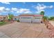 Charming single-story home boasting a tile roof, three-car garage, and mature landscaping under a colorful sunset sky at 10001 Cresent Creek Dr, Las Vegas, NV 89134