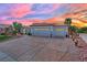 Charming single-story home boasting a tile roof, three-car garage, and mature landscaping under a colorful sunset sky at 10001 Cresent Creek Dr, Las Vegas, NV 89134