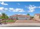 Attractive single-story home with a tile roof, well-manicured landscaping, and spacious driveway under a blue sky at 10001 Cresent Creek Dr, Las Vegas, NV 89134