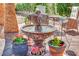 Outdoor fountain surrounded by colorful potted plants on a sunny patio, creating a relaxing ambiance at 10001 Cresent Creek Dr, Las Vegas, NV 89134