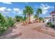 Lush desert landscaping with palm trees and stone walkway leading to a well-maintained home at 10001 Cresent Creek Dr, Las Vegas, NV 89134