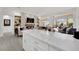 Open concept living room with white countertop island, stone fireplace, and large windows at 10001 Cresent Creek Dr, Las Vegas, NV 89134