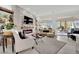 Stylish living room showcasing a stone fireplace, modern furnishings, and an open layout leading to outdoor spaces at 10001 Cresent Creek Dr, Las Vegas, NV 89134