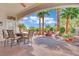 Covered patio with an outdoor dining area, comfortable seating, and landscaped garden at 10001 Cresent Creek Dr, Las Vegas, NV 89134