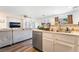 Open kitchen view features an island sink with seating, stainless steel dishwasher, and wood floors at 1041 Grand Cerritos Ave, Las Vegas, NV 89183