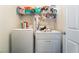 Functional laundry area with a washer, dryer, and shelving for storage at 1041 Grand Cerritos Ave, Las Vegas, NV 89183