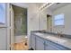 Updated bathroom features double sinks, granite counters, and a shower and tub with glass door at 11073 Gateview Ln, Las Vegas, NV 89144