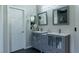 Bathroom featuring double sink vanities, modern lighting, and a mirrored medicine cabinet at 11244 Gammila Dr, Las Vegas, NV 89141