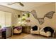 Well-lit bedroom with wall art, a ceiling fan, and cozy seating area at 11244 Gammila Dr, Las Vegas, NV 89141