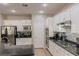 Modern kitchen with stainless steel appliances, white cabinets, and black countertops at 11244 Gammila Dr, Las Vegas, NV 89141