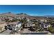 An aerial view of a suburban neighborhood showcases lovely homes against the backdrop of beautiful mountains at 12124 Kite Hill Ln, Las Vegas, NV 89138