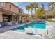 Luxury backyard pool with a tanning ledge, seating area, and a covered patio for outdoor living at 12124 Kite Hill Ln, Las Vegas, NV 89138