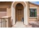 Inviting home entrance with a wooden door, arched entrance, and brick walkway offers great curb appeal at 12124 Kite Hill Ln, Las Vegas, NV 89138
