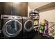 Well-organized laundry room with modern washer, dryer, and storage shelves at 12124 Kite Hill Ln, Las Vegas, NV 89138
