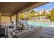 Inviting covered patio with comfortable seating overlooks the refreshing pool and manicured landscaping at 12124 Kite Hill Ln, Las Vegas, NV 89138