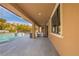 Spacious covered patio with outdoor seating offers serene views of the pool and landscaped backyard at 12124 Kite Hill Ln, Las Vegas, NV 89138