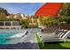 Inviting pool area with loungers, a shade umbrella, and lush landscaping for ultimate relaxation at 12124 Kite Hill Ln, Las Vegas, NV 89138