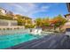 Stunning pool area features in-pool loungers, stylish deck chairs, and a vibrant orange sunshade at 12124 Kite Hill Ln, Las Vegas, NV 89138