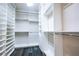This is a large walk-in closet with custom white shelving, and hardwood flooring at 12124 Kite Hill Ln, Las Vegas, NV 89138