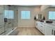 Bright bathroom with white cabinetry, modern fixtures, and a frameless glass shower with marble accents at 12428 Lincoln Creek Ave, Las Vegas, NV 89138